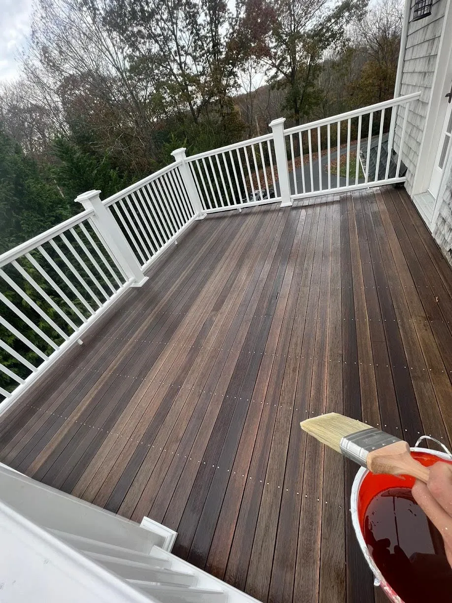 Professional deck refinishing with mahogany stain and white railings on the South Shore