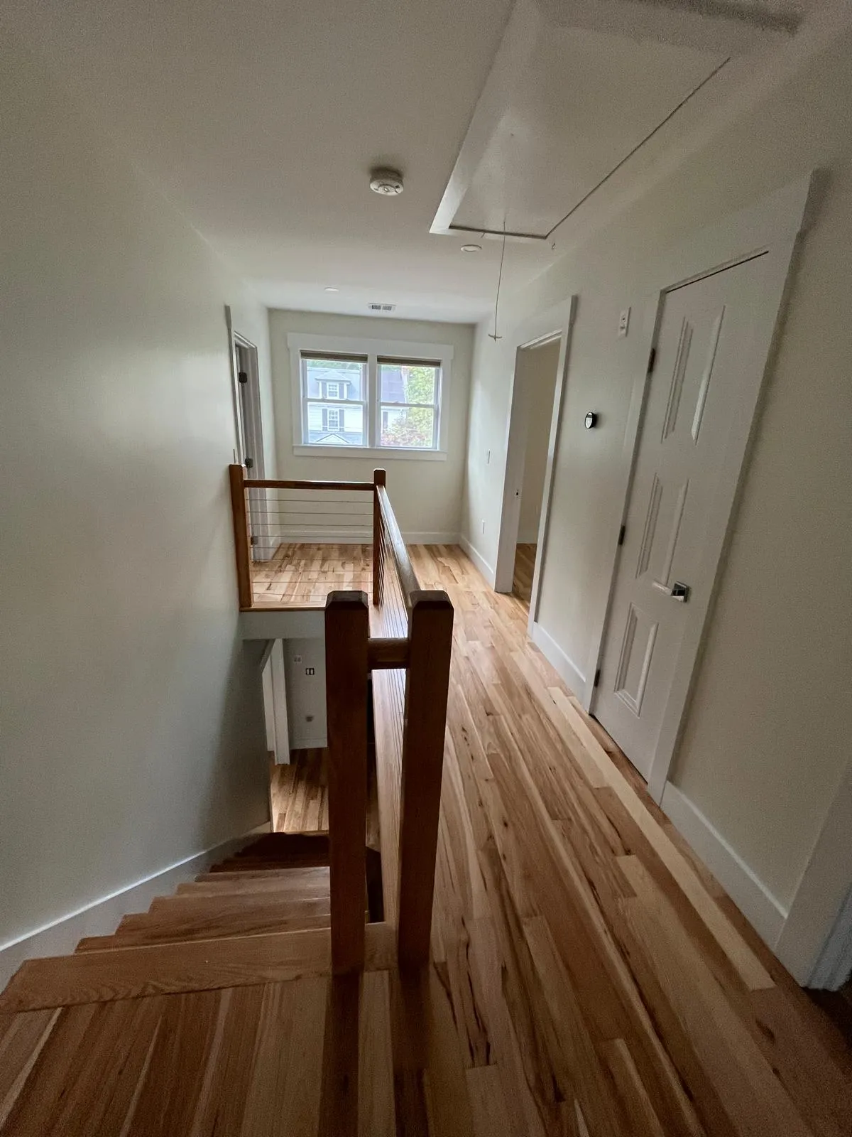 Professional hallway and staircase interior painting with white walls in Somerville MA home